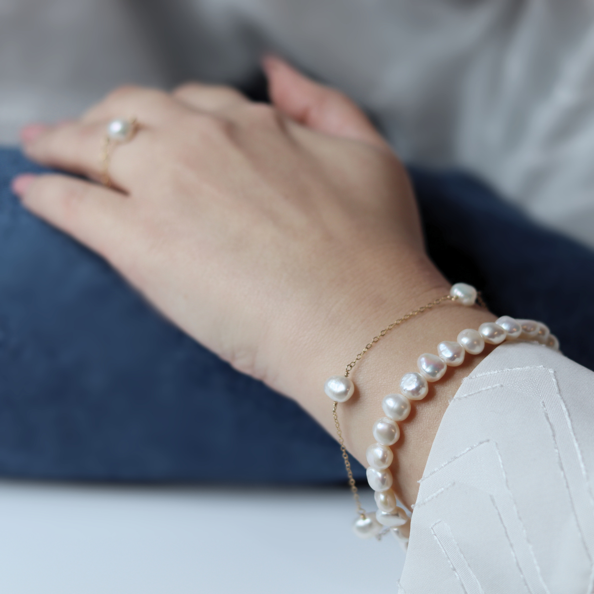 A stylish white baroque pearl bracelet adorned with a gold extension chain, highlighting a refined and contemporary aesthetic.