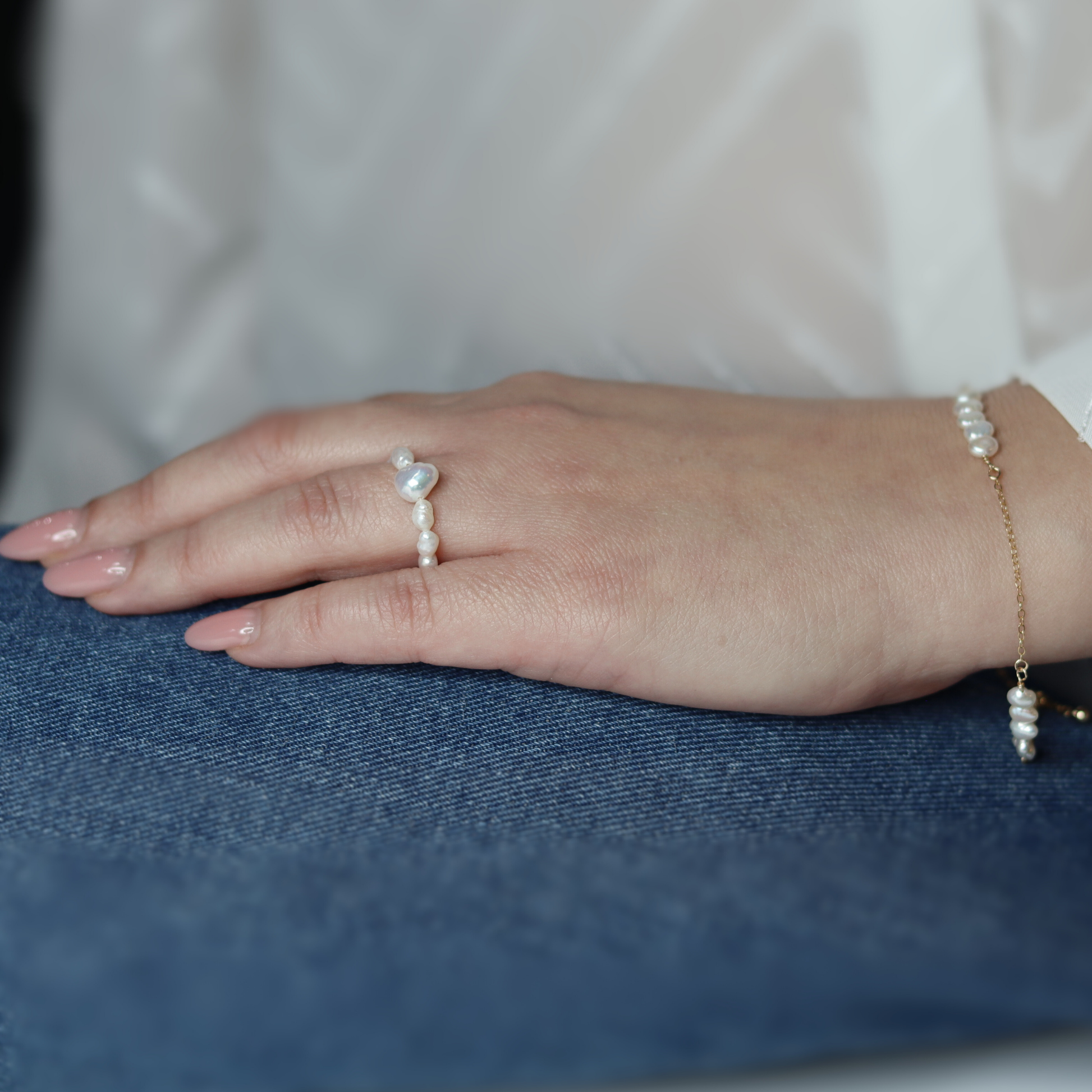 A delicate chain bracelet featuring clusters of four small, lustrous pearls elegantly arranged along its length.