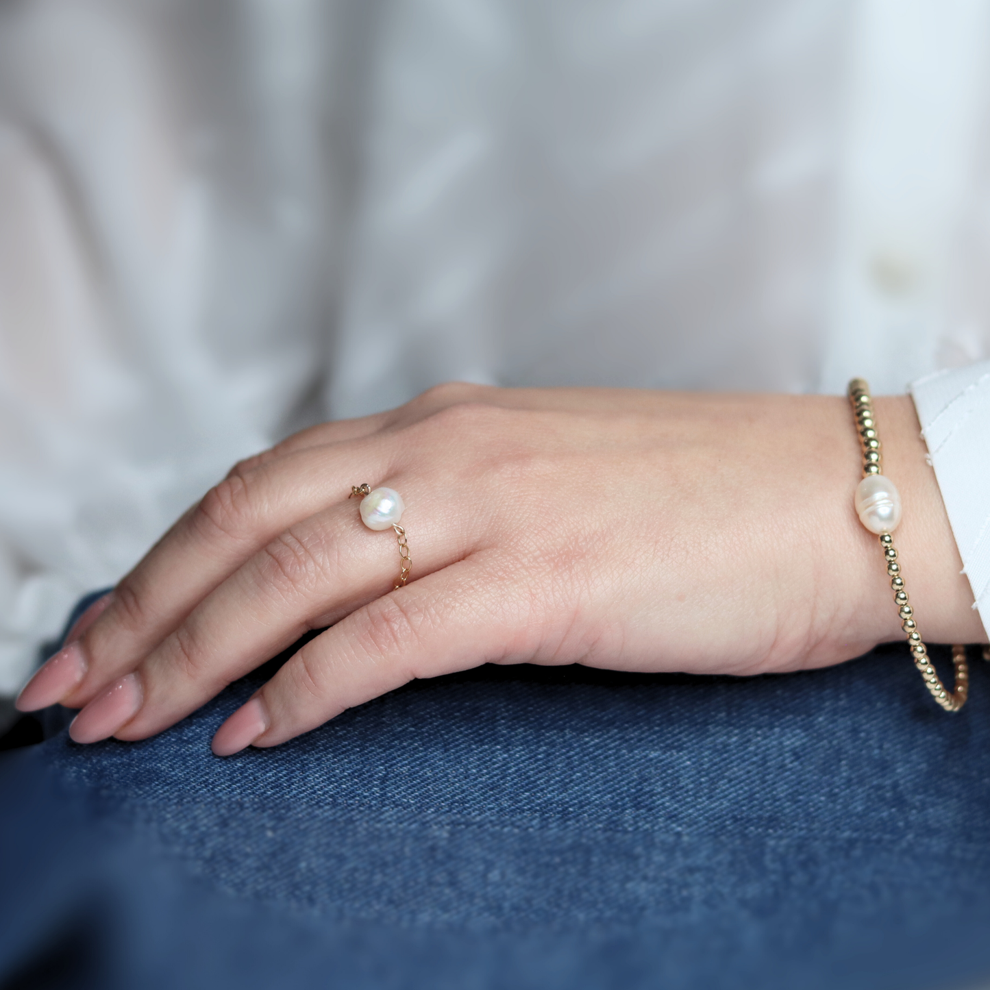 An exquisite gold beads bracelet with a prominent pearl, embodying elegance and timeless beauty.