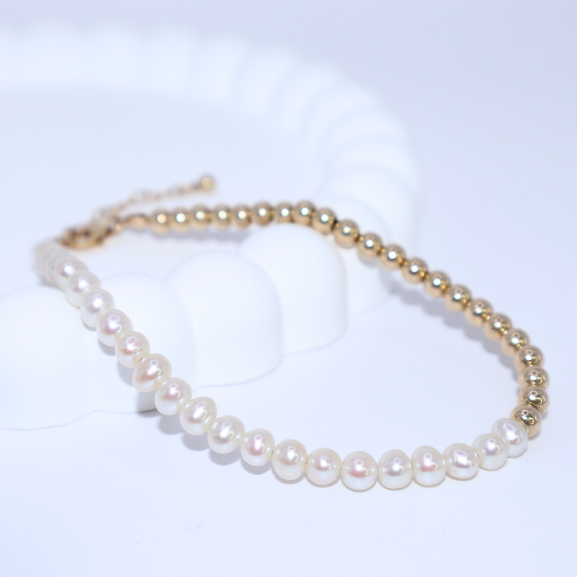 A stunning gold beads and white pearl bracelet, beautifully crafted to enhance any outfit with its refined and classic appeal.