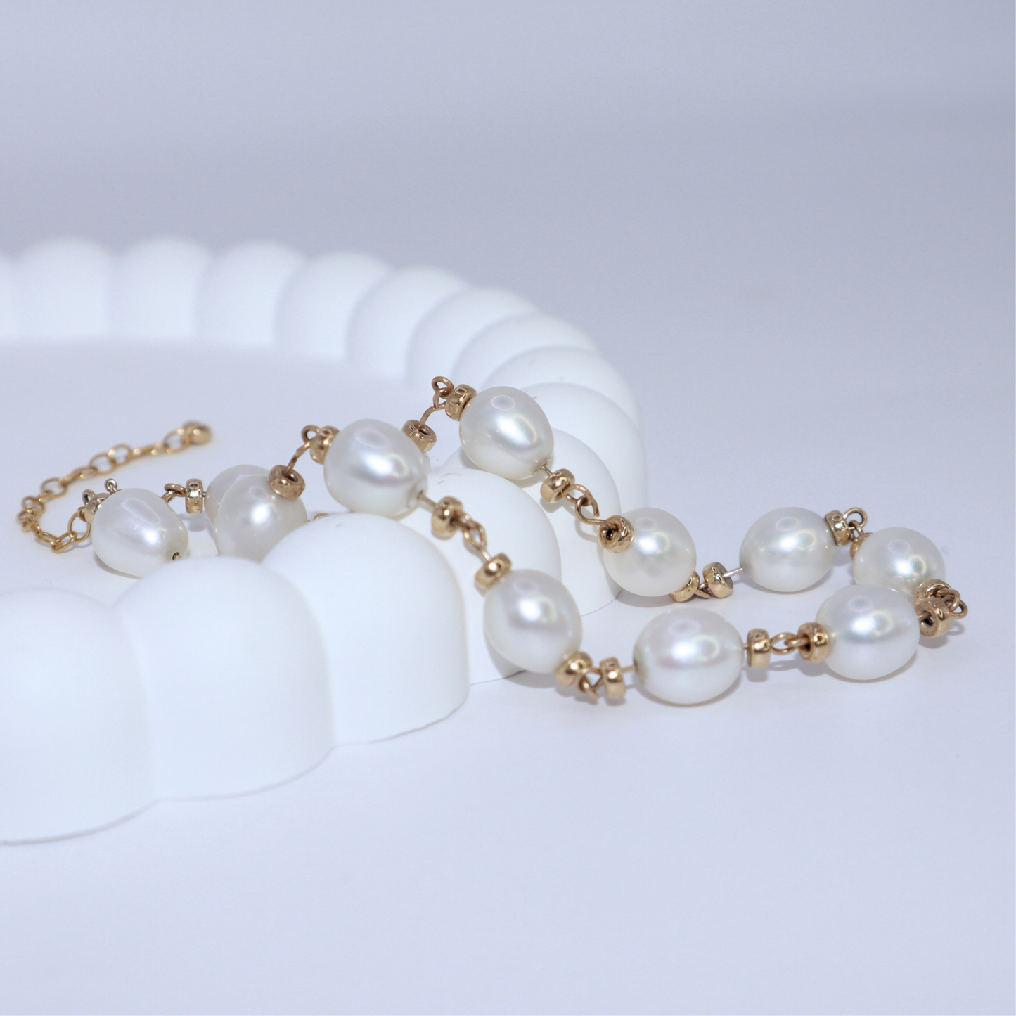 A stunning bracelet featuring lustrous white pearls and gold rondelle beads intertwined with a luxurious gold chain, perfect for any occasion.