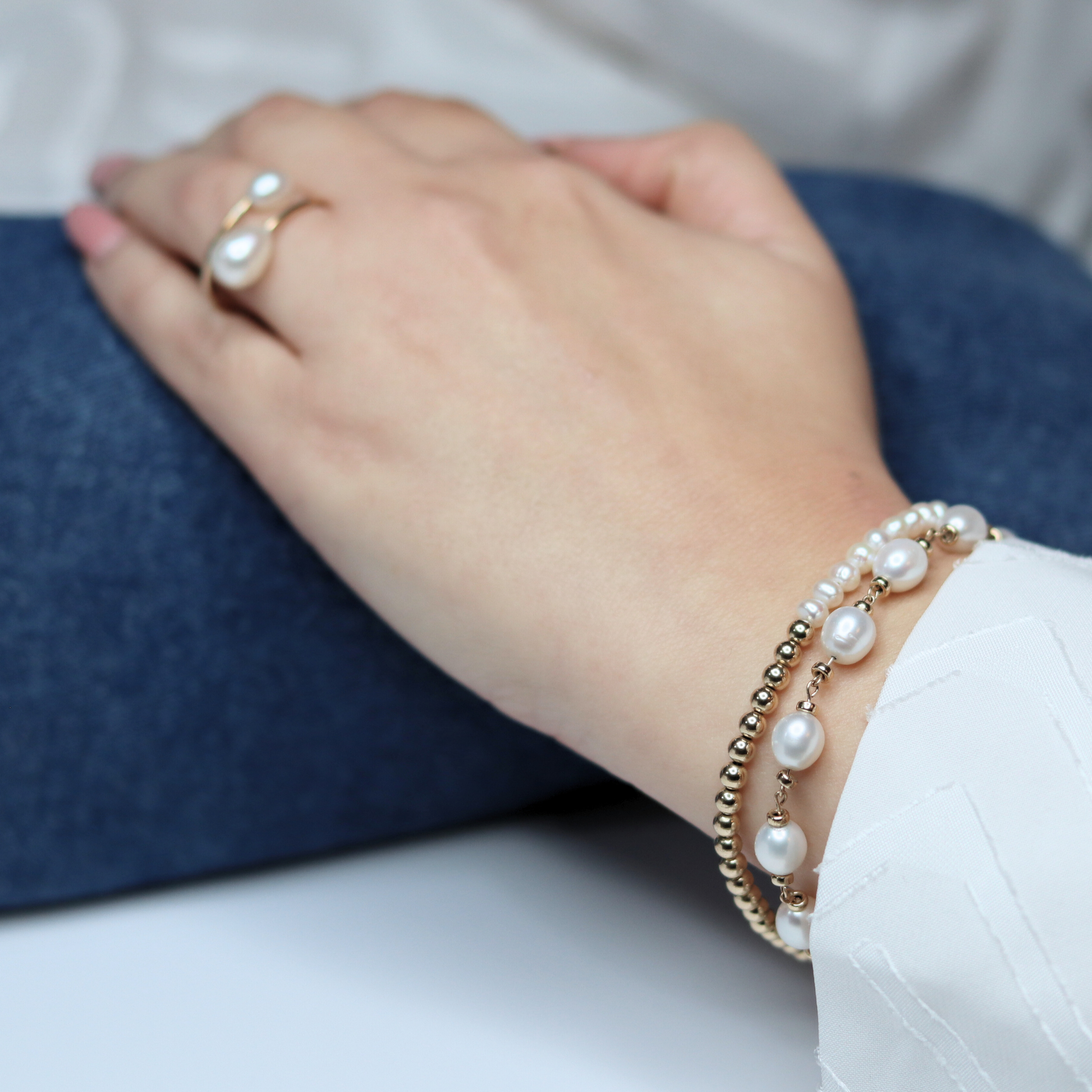 A stunning bracelet featuring lustrous white pearls and gold rondelle beads intertwined with a luxurious gold chain, perfect for any occasion.