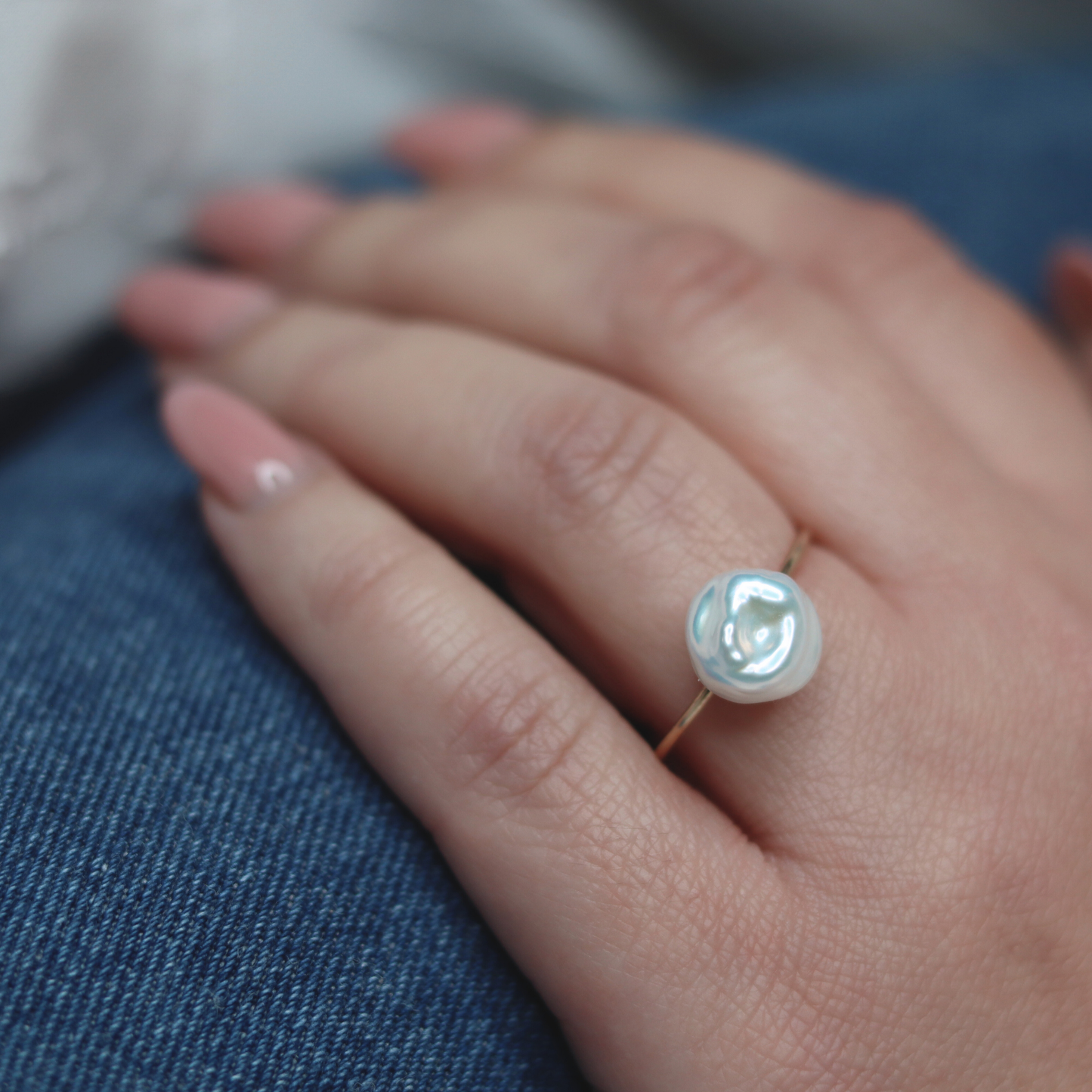 A beautiful baroque pearl gracefully perched on a gleaming gold ring, symbolizing elegance and refined taste.