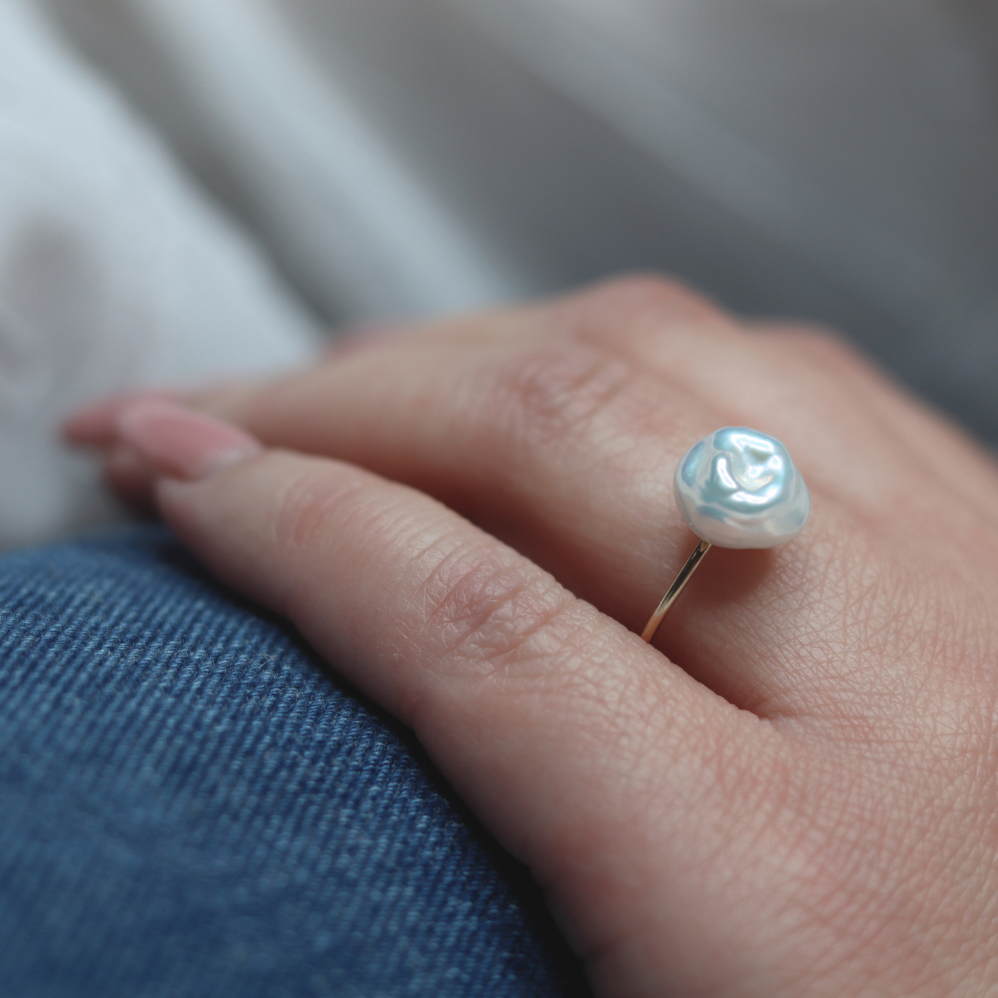 A beautiful baroque pearl gracefully perched on a gleaming gold ring, symbolizing elegance and refined taste.