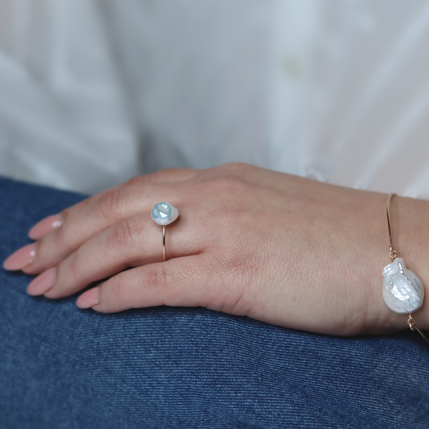 A beautiful baroque pearl gracefully perched on a gleaming gold ring, symbolizing elegance and refined taste.