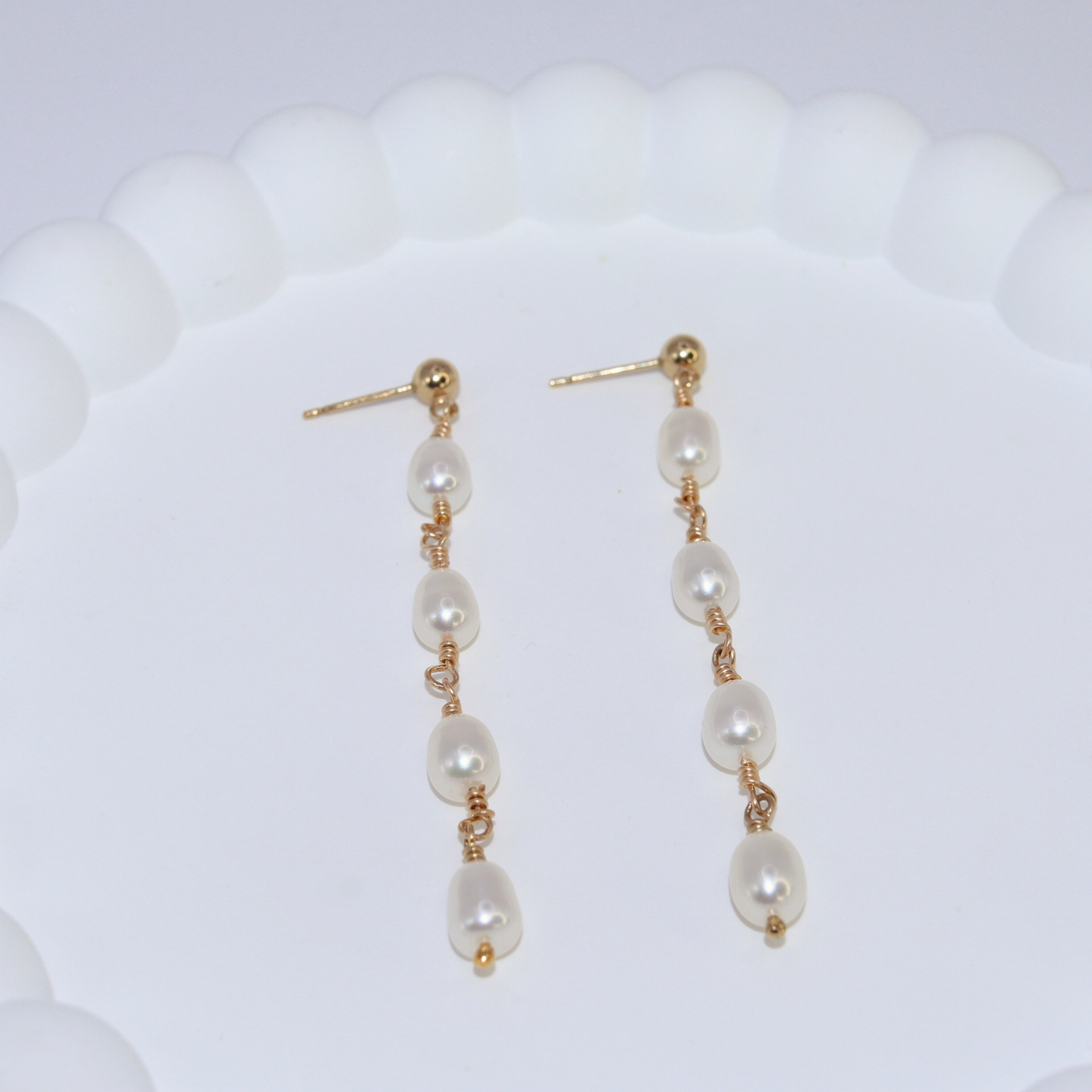 Elegant gold and four ivory pearl drop earrings, exuding sophistication and timeless beauty, perfect for any luxurious occasion.