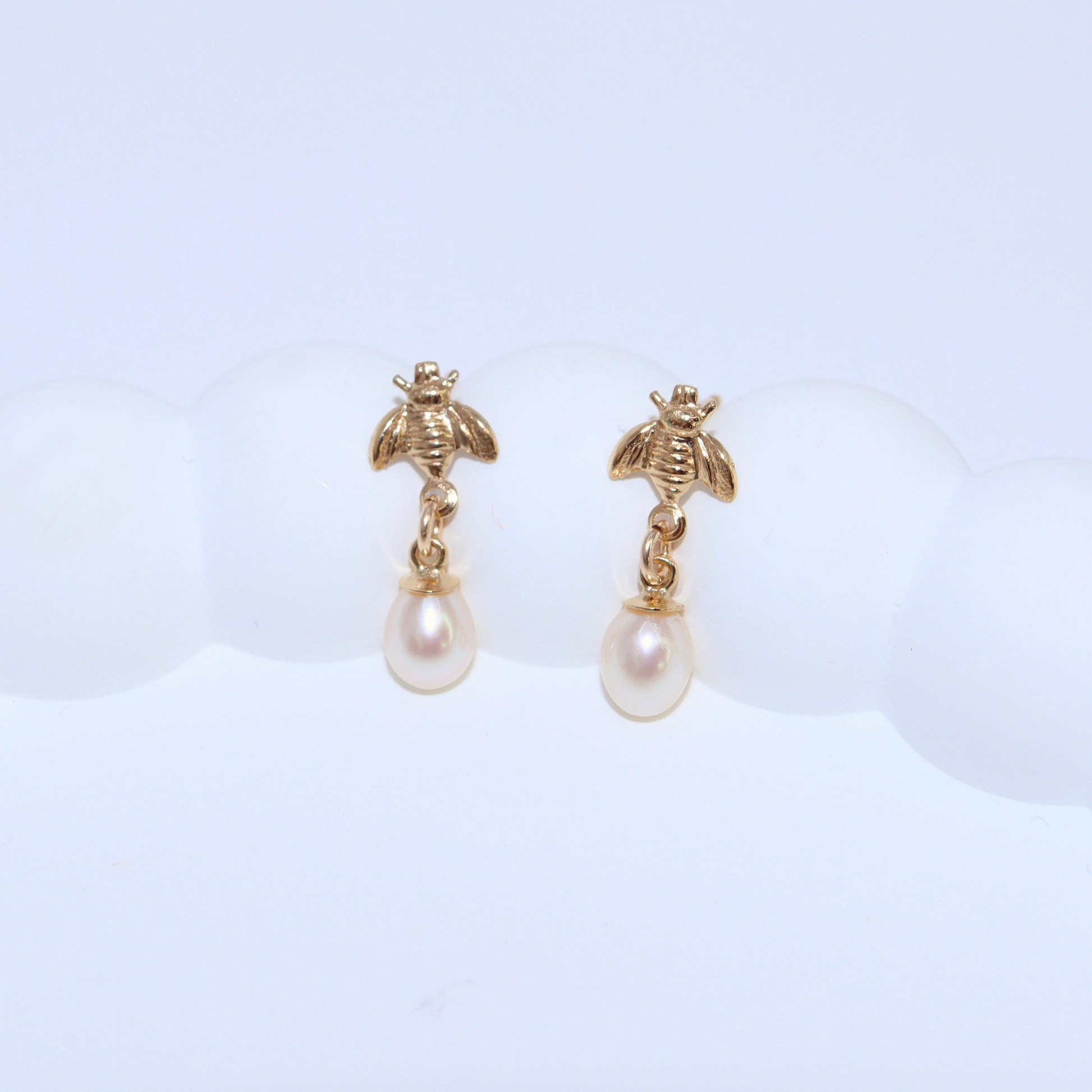 These small teardrop pearls add a touch of elegance to any look, while the playful bee studs bring a fun and unique element.