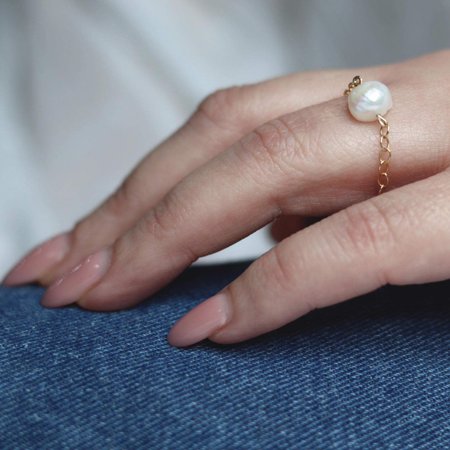 A stunning pearl ring featuring a delicate gold chain, embodying grace in every detail.