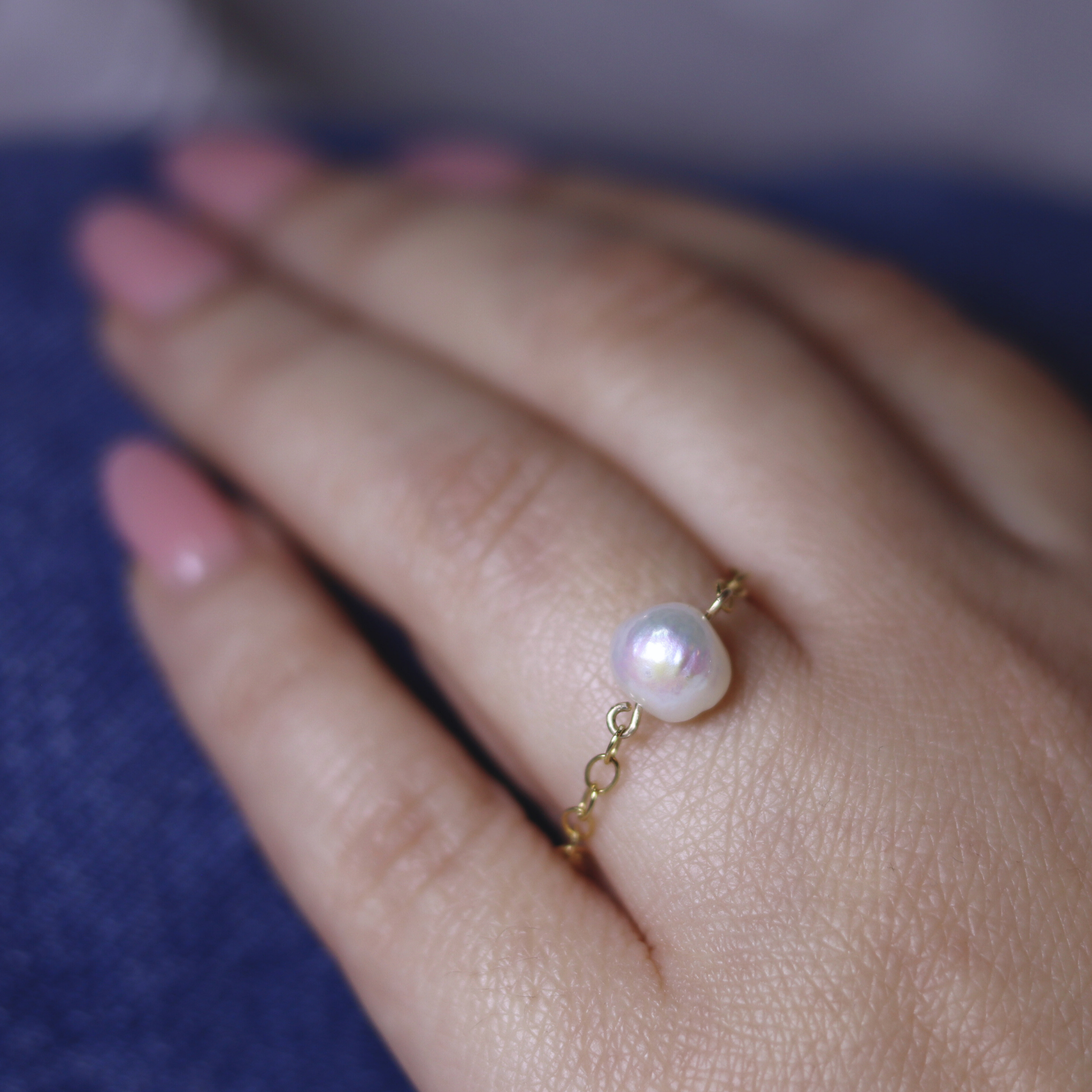 A stunning pearl ring featuring a delicate gold chain, embodying grace in every detail.