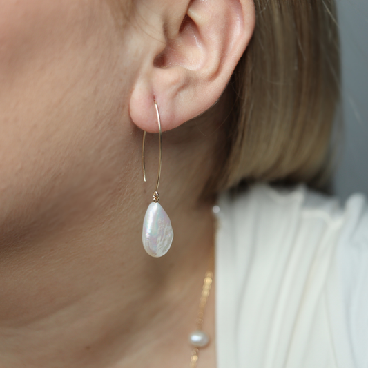 Featuring large flat teardrop pearls and V-shaped pull through design, these earrings exude sophistication and luxury.