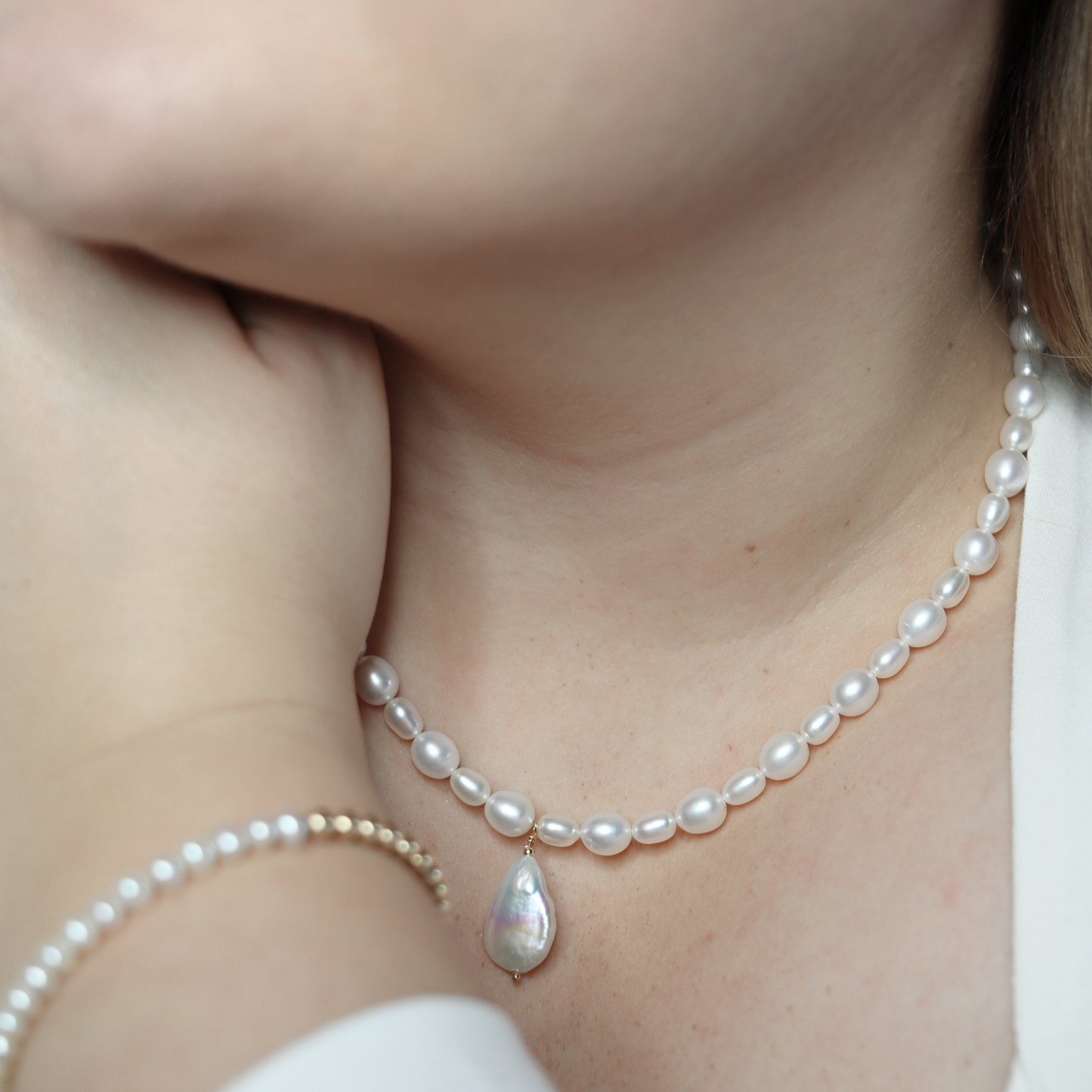 A stunning white pearl necklace adorned with a teardrop pearl pendant, exemplifying elegance and classic style.