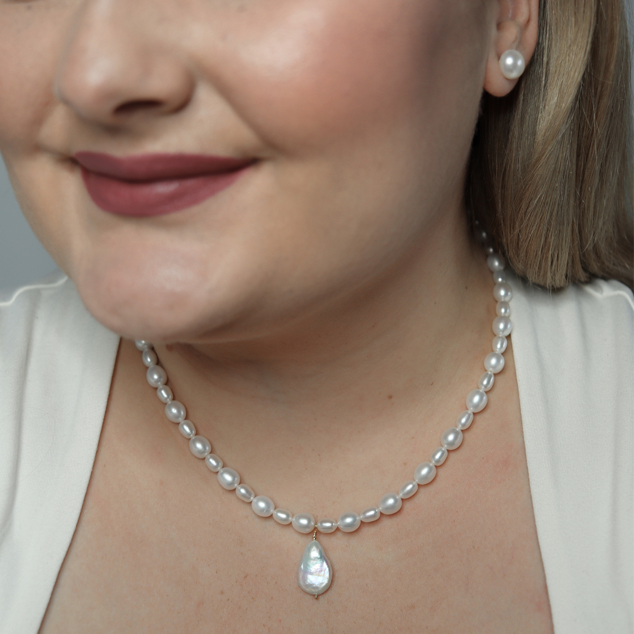 A stunning white pearl necklace adorned with a teardrop pearl pendant, exemplifying elegance and classic style.