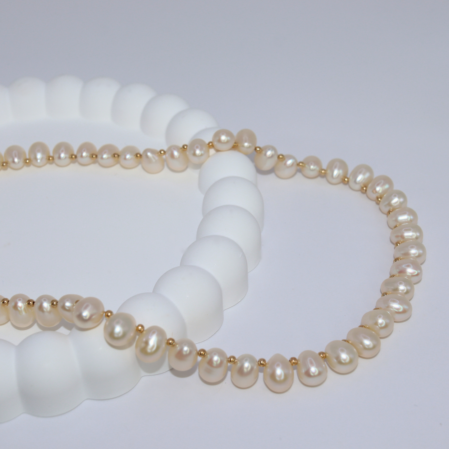 A stunning ivory teardrop pearl necklace complemented by gleaming gold beads, embodying elegance and classic style.