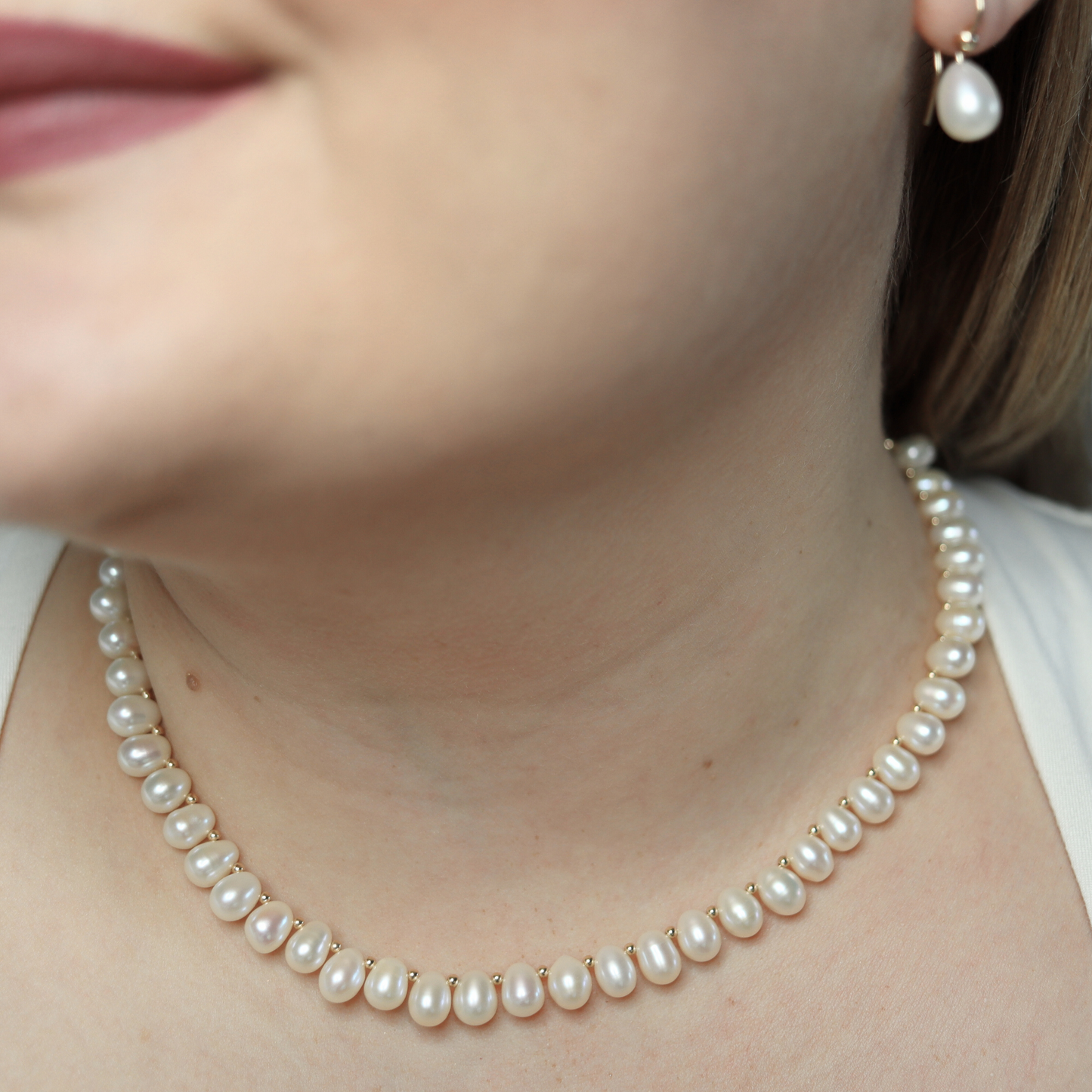 A stunning ivory teardrop pearl necklace complemented by gleaming gold beads, embodying elegance and classic style.