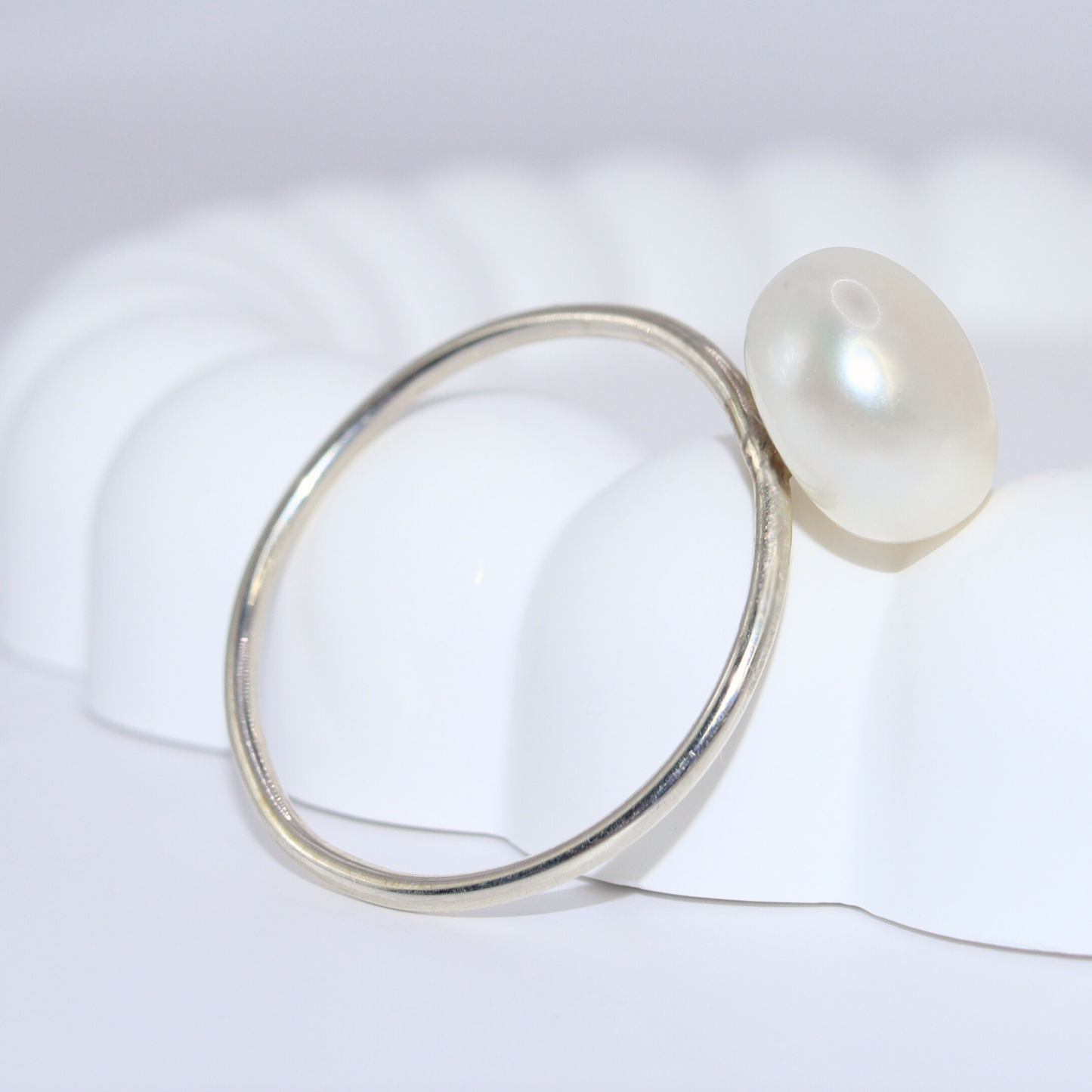 A luxurious silver ring adorned with a large exquisite pearl, radiating elegance and timeless beauty.