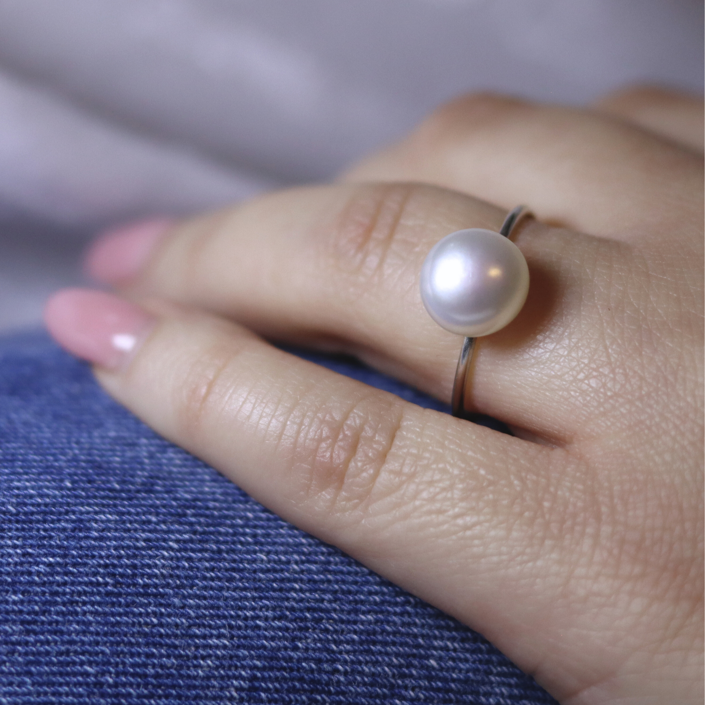 A luxurious silver ring adorned with a large exquisite pearl, radiating elegance and timeless beauty.