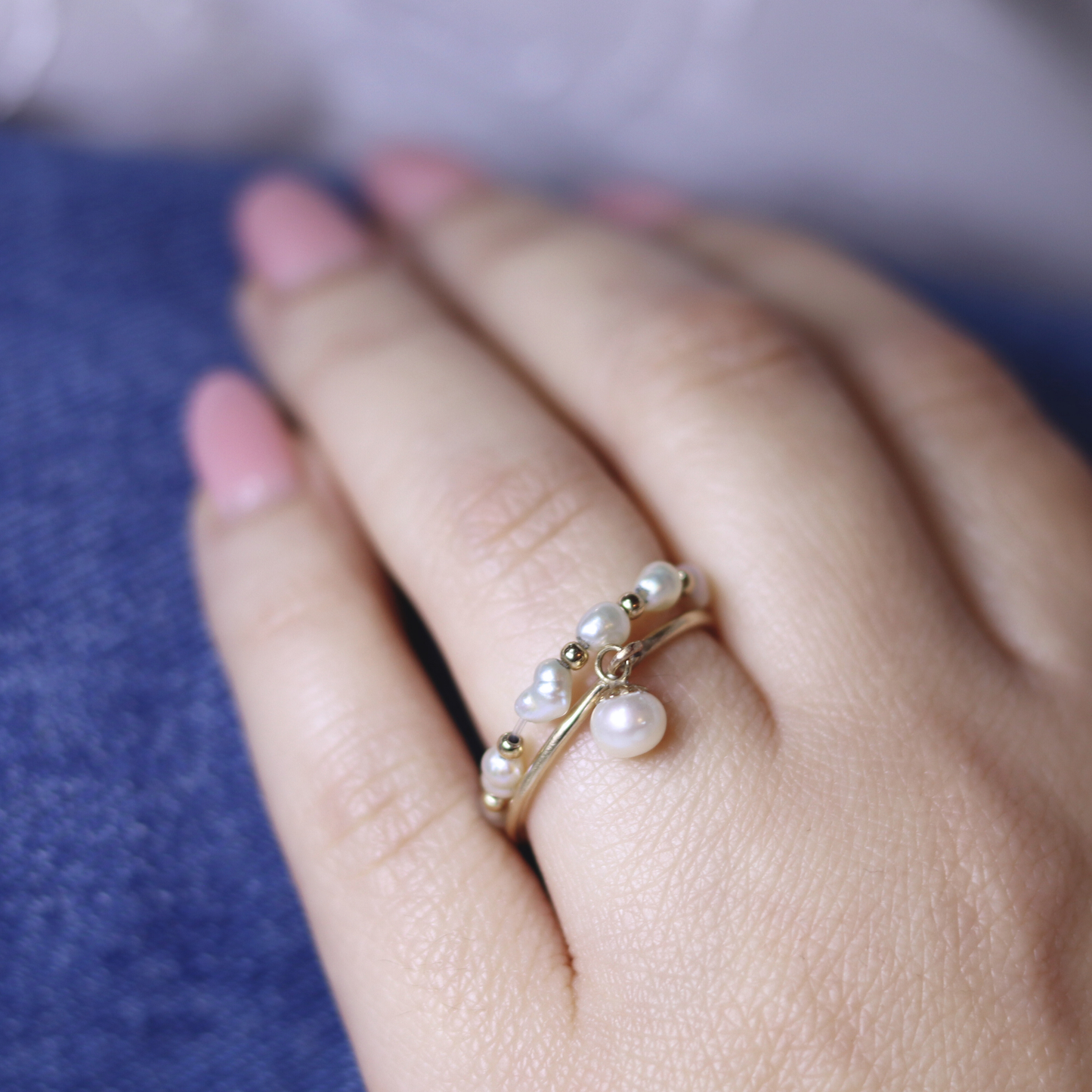 A luxurious gold ring adorned with a single exquisite pearl charm, radiating elegance and timeless beauty.
