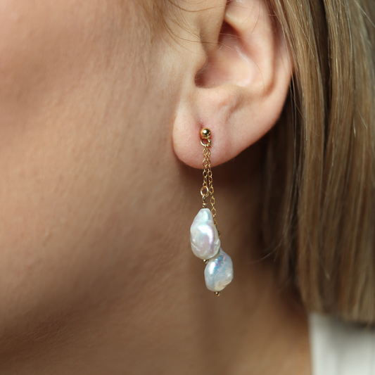 Featuring stunning baroque pearls dangling on dainty chains, these earrings exude elegance and luxury.