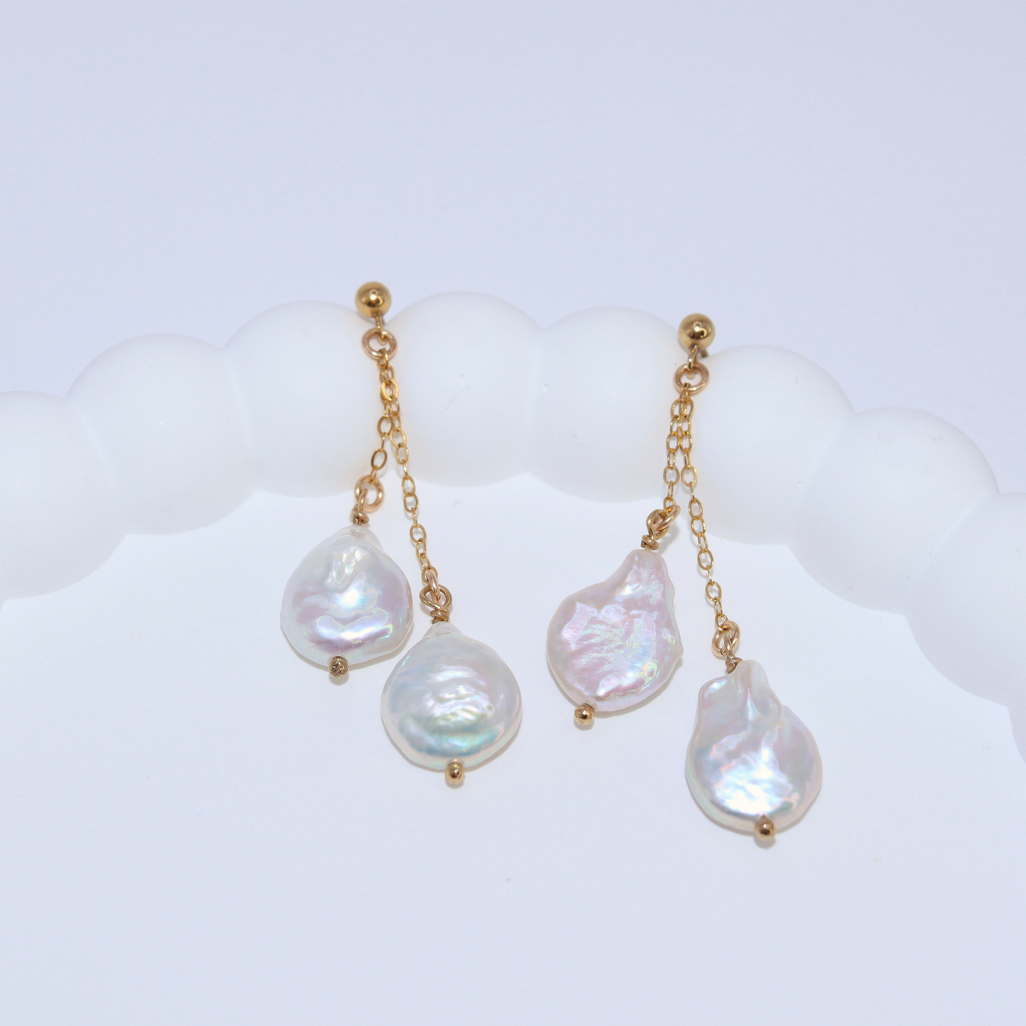 Featuring stunning baroque pearls dangling on dainty chains, these earrings exude elegance and luxury.