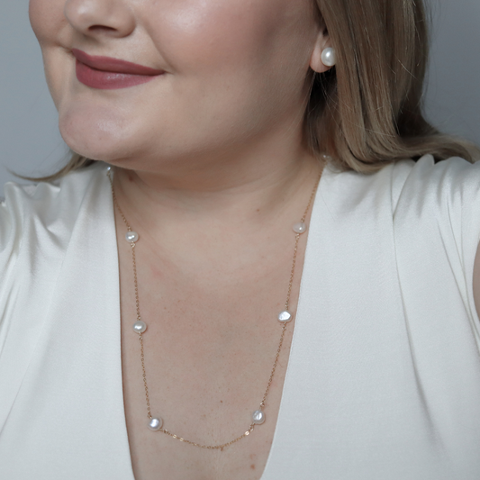 A long necklace featuring an elegant arrangement of ivory baroque pearls, showcasing a sophisticated design.