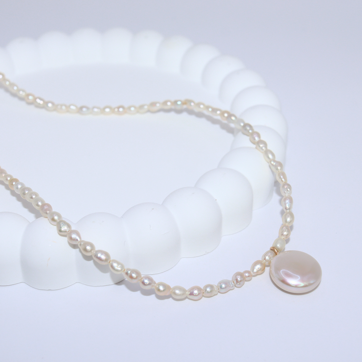 A refined white pearl necklace adorned with a coin pearl pendant, showcasing simplicity and elegance.