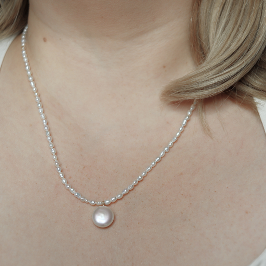 A refined white pearl necklace adorned with a coin pearl pendant, showcasing simplicity and elegance.