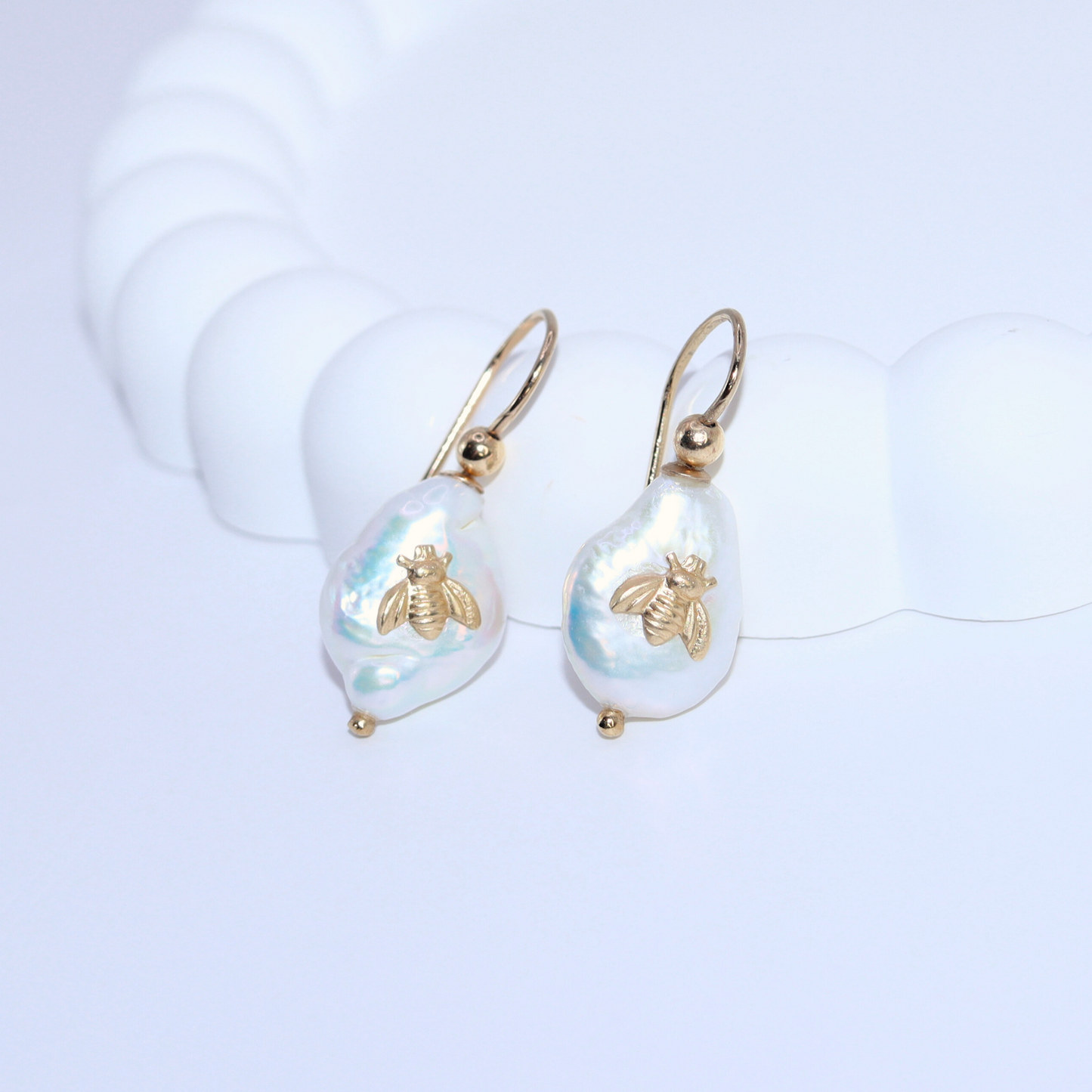 Featuring a delicate bee accent, these hook-style baroque pearl earrings will elevate your look with a touch of playfulness.