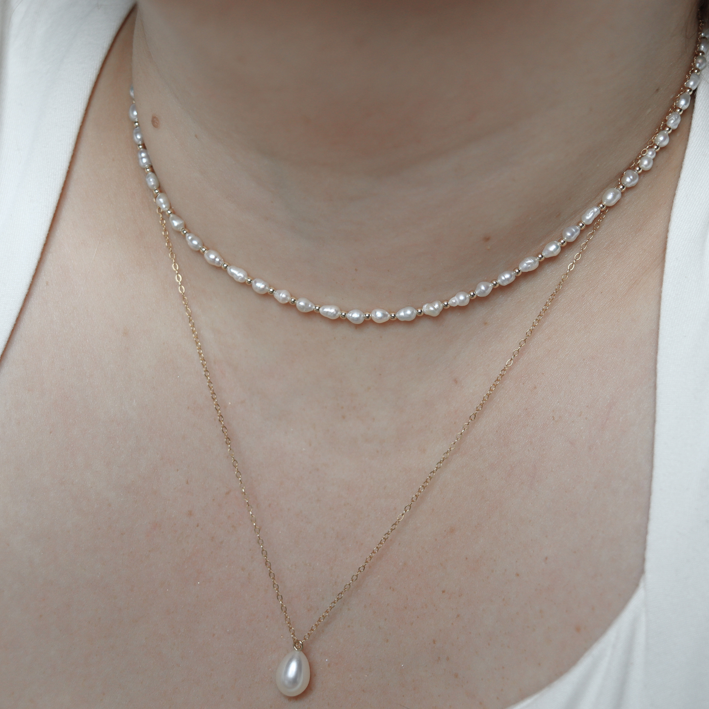 An elegant gold beads and tiny ivory pearls necklace, featuring a harmonious blend of colors and a sophisticated design.