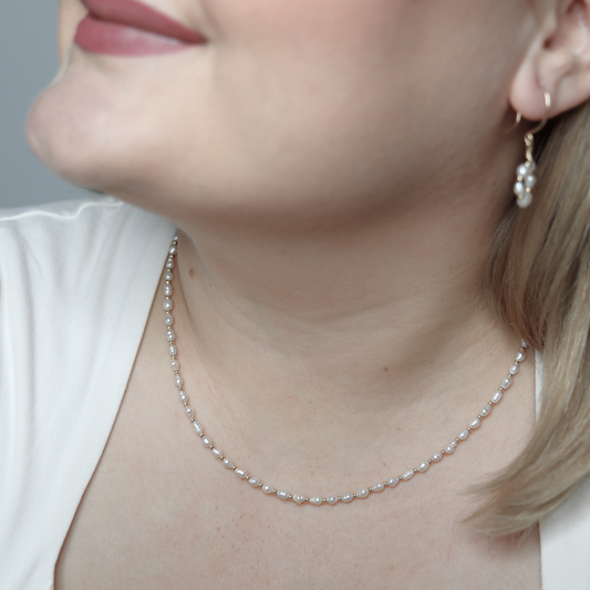 An elegant gold beads and tiny ivory pearls necklace, featuring a harmonious blend of colors and a sophisticated design.