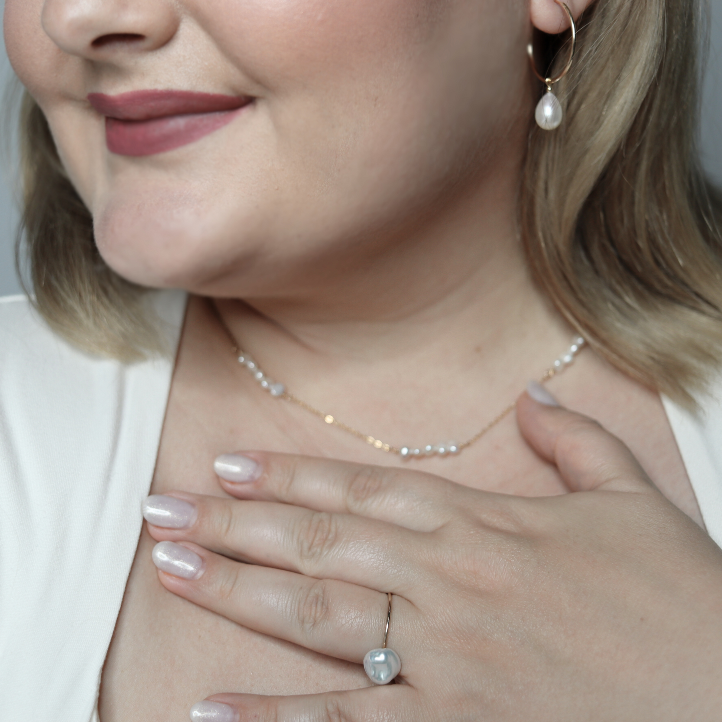 A delicate chain necklace featuring clusters of four small, lustrous pearls elegantly arranged along its length.