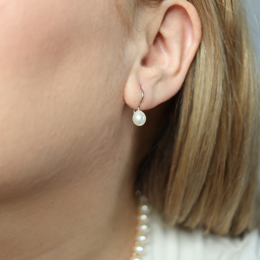 Adorned with elegant teardrop pearls, these simple yet sophisticated hook earrings are the perfect accessory for any occasion.
