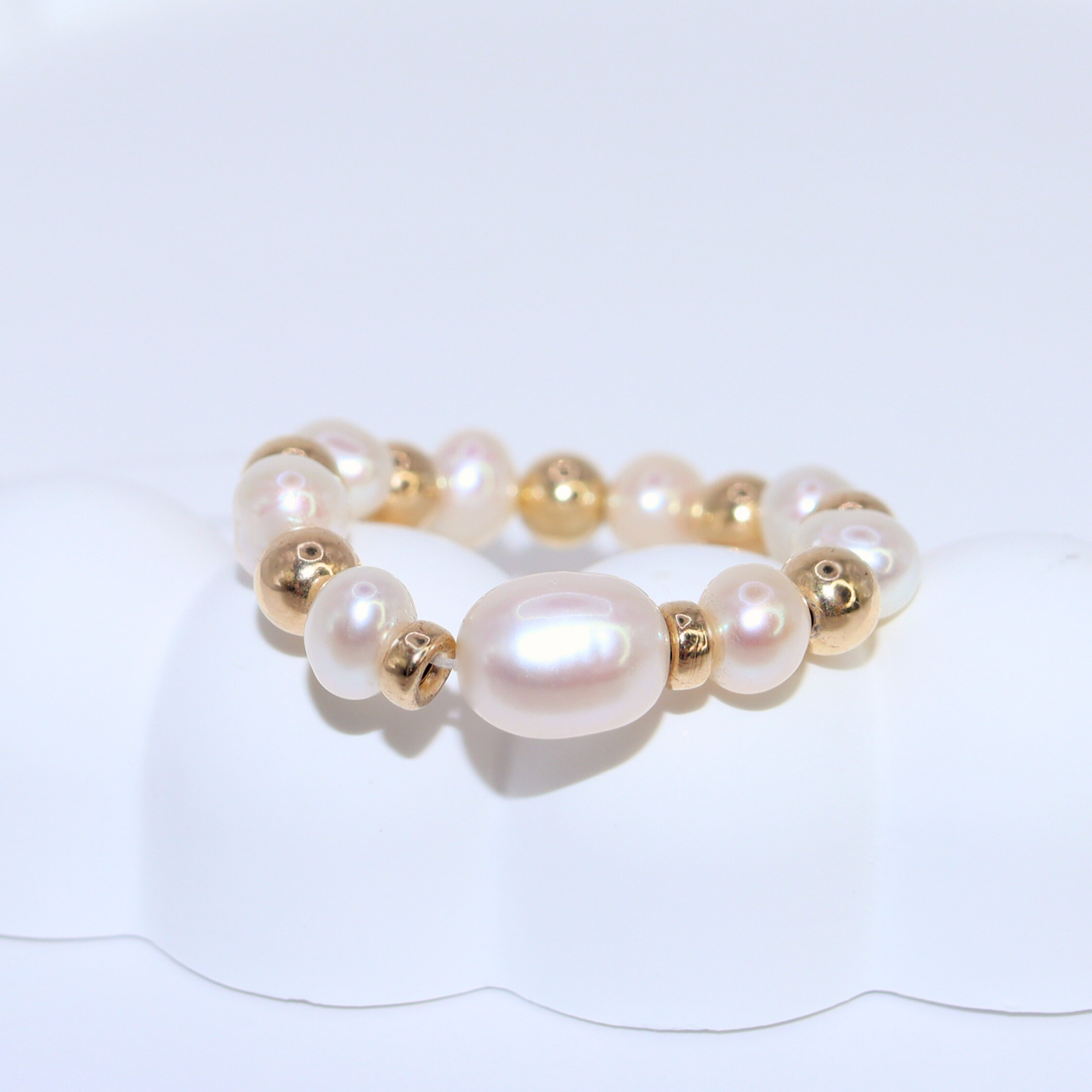 Exquisite gold beads and white pearl ring, a timeless accessory that embodies elegance and refined style.