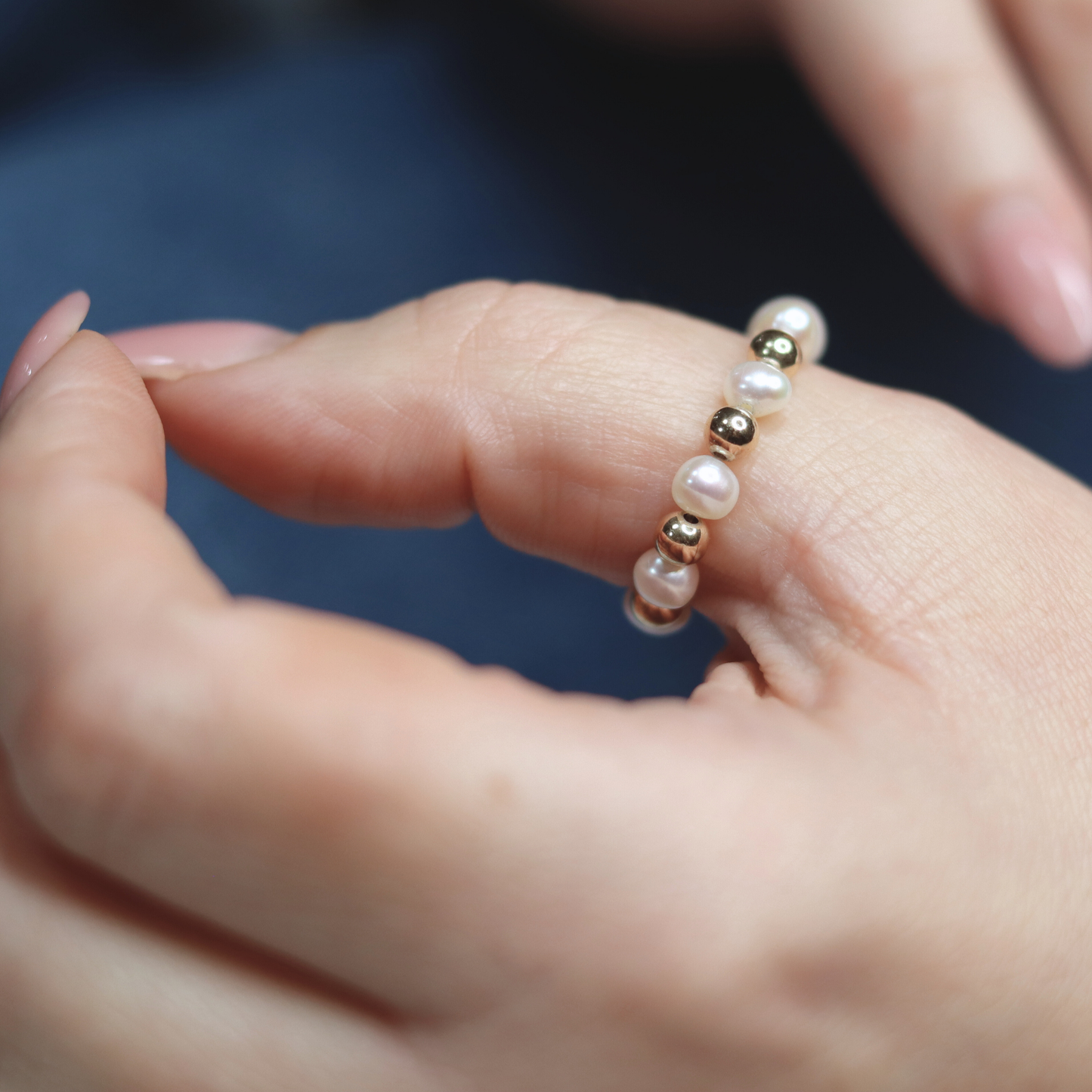 Exquisite gold beads and white pearl ring, a timeless accessory that embodies elegance and refined style.