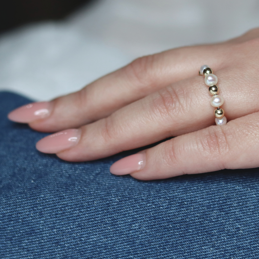 Exquisite gold beads and white pearl ring, a timeless accessory that embodies elegance and refined style.