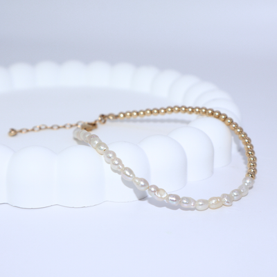 A stunning gold beads and white pearl bracelet, beautifully crafted to enhance any outfit with its refined and classic appeal.