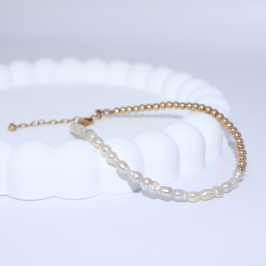 A stunning gold beads and white pearl bracelet, beautifully crafted to enhance any outfit with its refined and classic appeal.