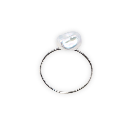 A beautiful baroque pearl gracefully perched on a gleaming silver ring, symbolizing elegance and refined taste.