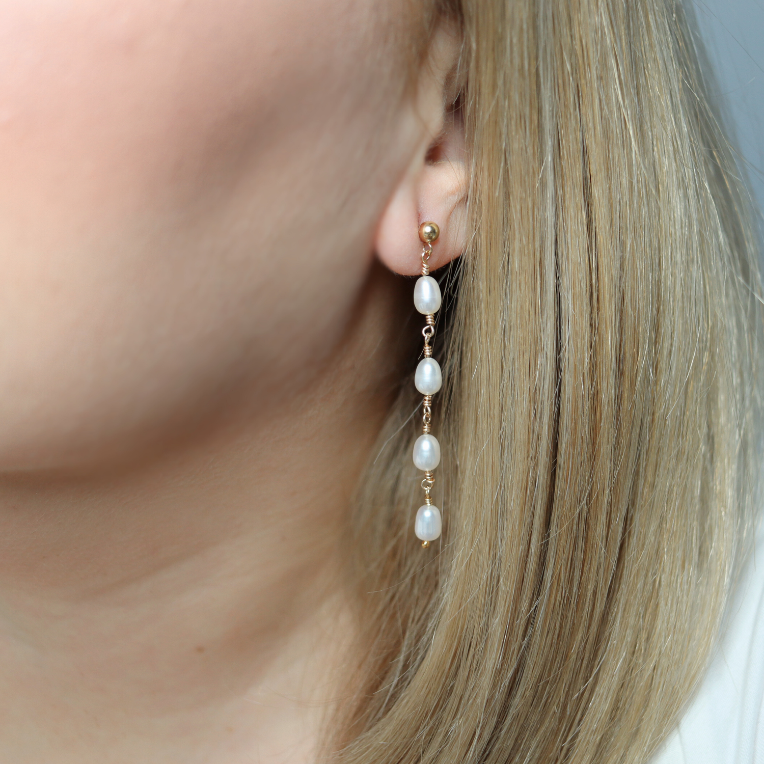 Elegant gold and four ivory pearl drop earrings, exuding sophistication and timeless beauty, perfect for any luxurious occasion.