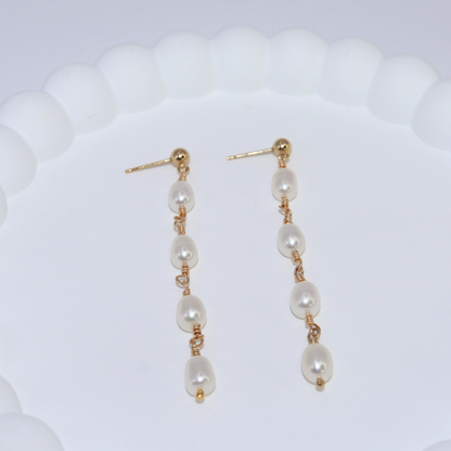 Elegant gold and four ivory pearl drop earrings, exuding sophistication and timeless beauty, perfect for any luxurious occasion.