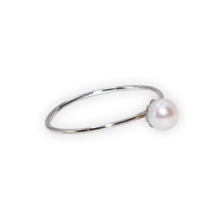 An exquisite silver ring featuring a single, lustrous pearl set on a flower base, embodying sophistication and grace.