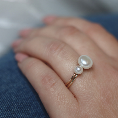 An exquisite gold ring featuring a single, lustrous pearl set on a flower base, embodying sophistication and grace.