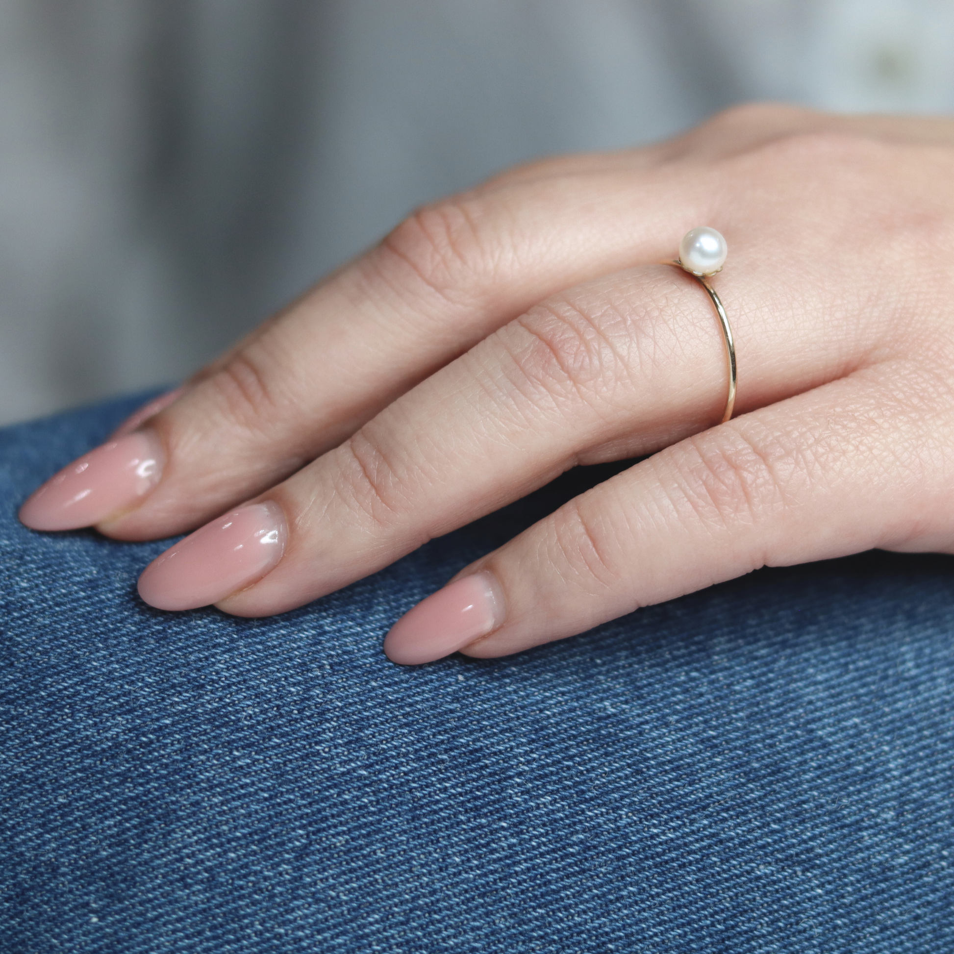 An exquisite gold ring featuring a single, lustrous pearl set on a flower base, embodying sophistication and grace.