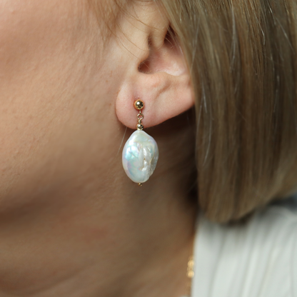  These exquisite earrings feature large baroque pearls delicately suspended from a classic ball stud. 