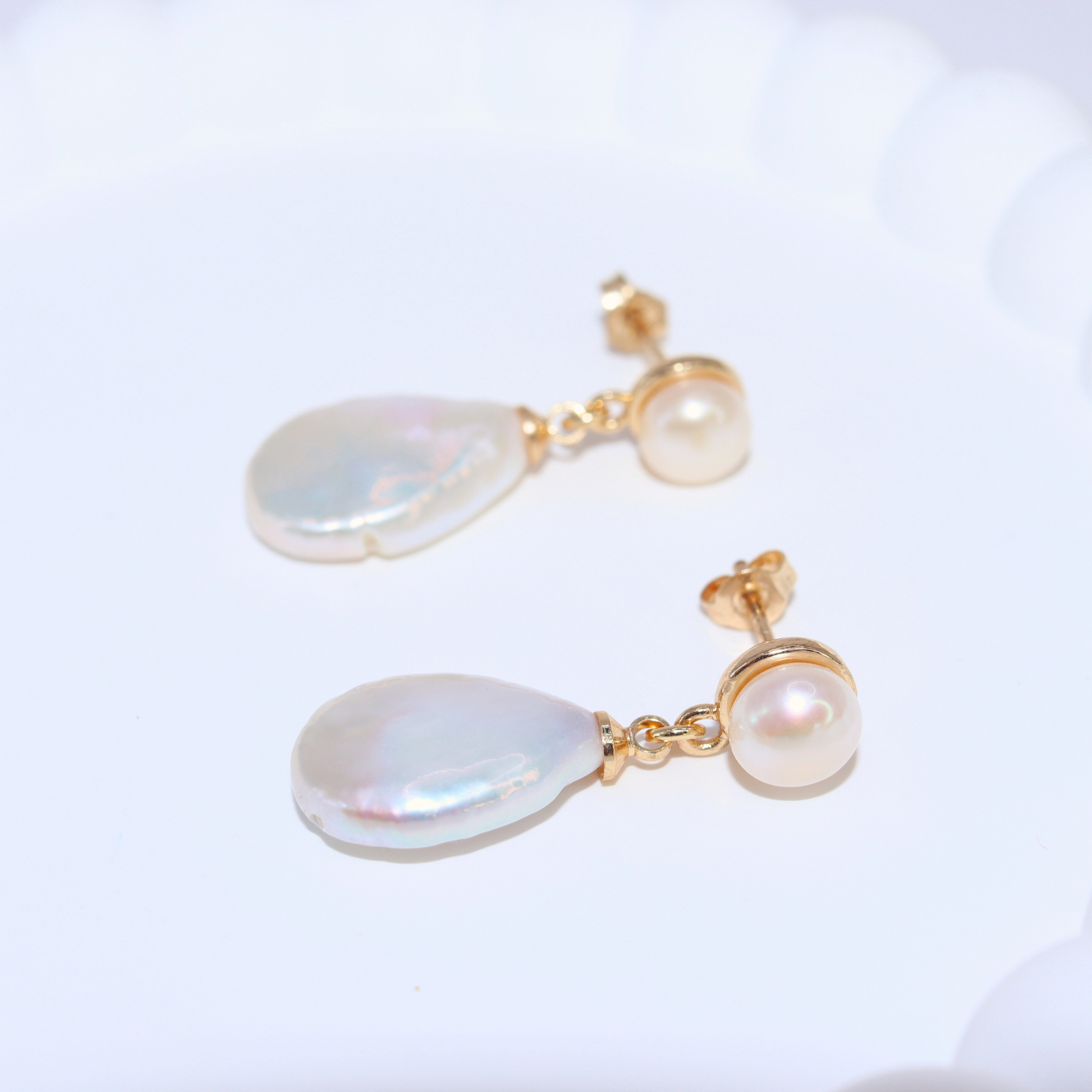 Featuring pearl studs and flat teardrop dangles, these earrings exude elegance and sophistication.