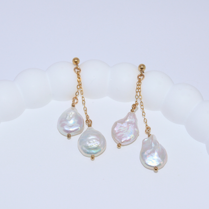 Featuring stunning baroque pearls dangling on dainty chains, these earrings exude elegance and luxury.