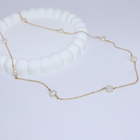 A long necklace featuring an elegant arrangement of ivory baroque pearls, showcasing a sophisticated design.