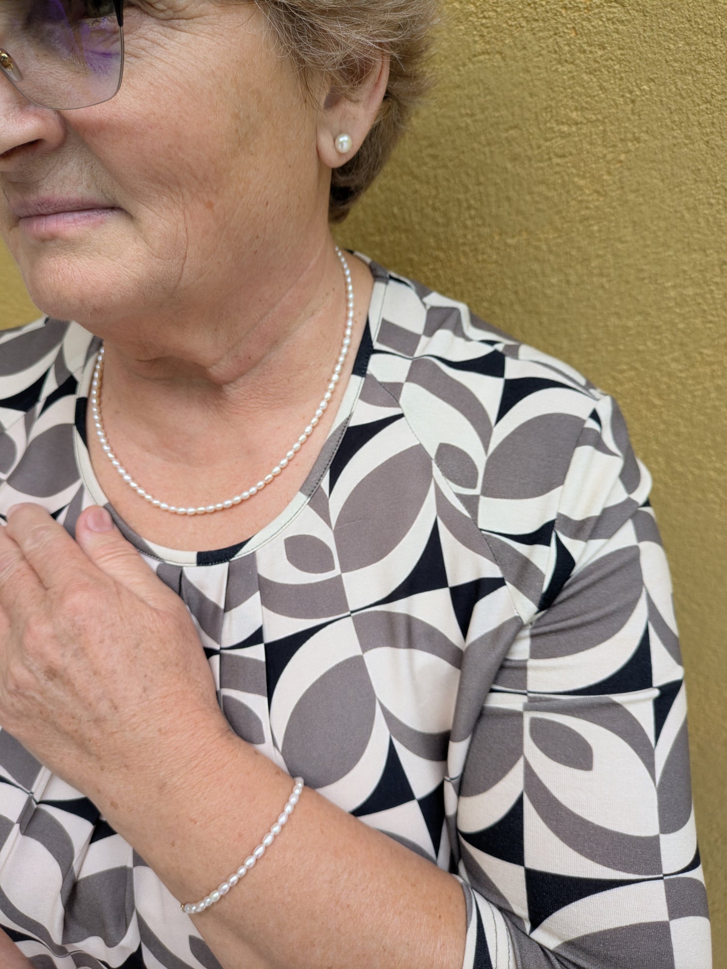 Woman wearing a pearl necklace and bracelet.