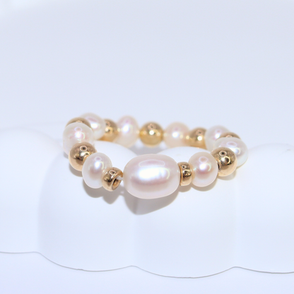 Exquisite gold beads and white pearl ring, a timeless accessory that embodies elegance and refined style.