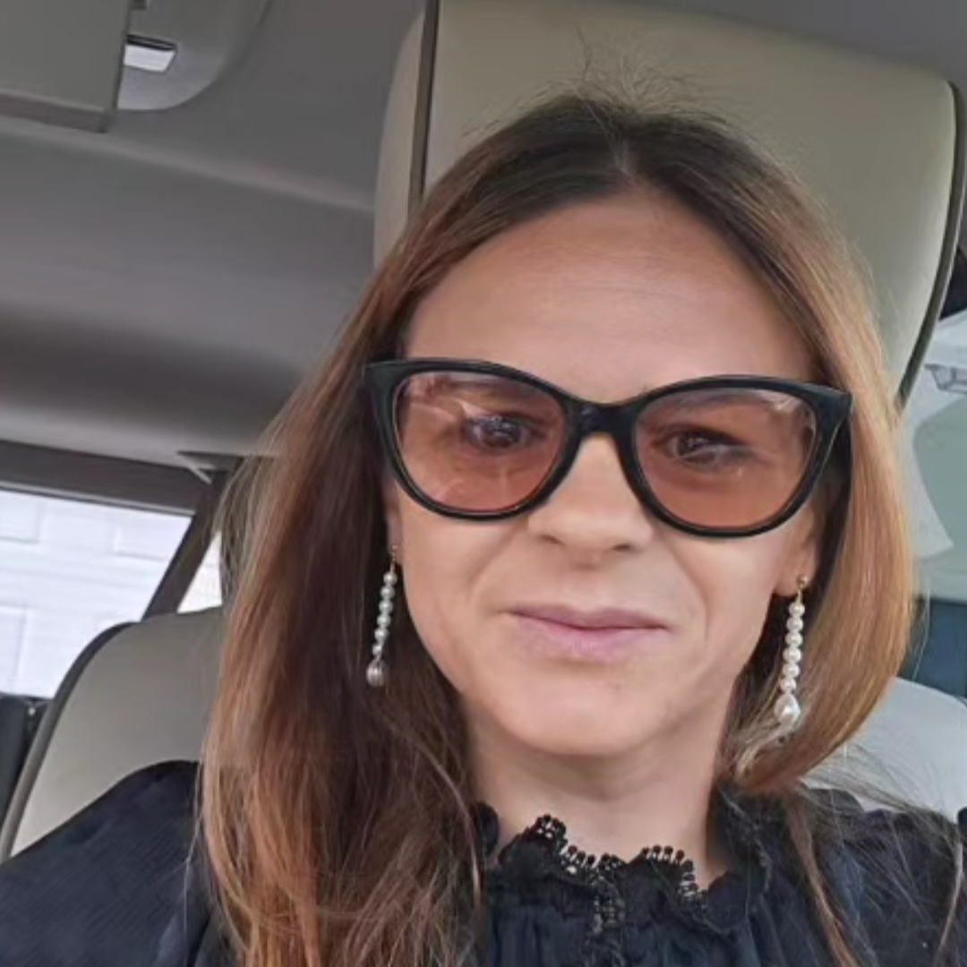Woman wearing sunglasses and the vivienne earrings inside a vehicle